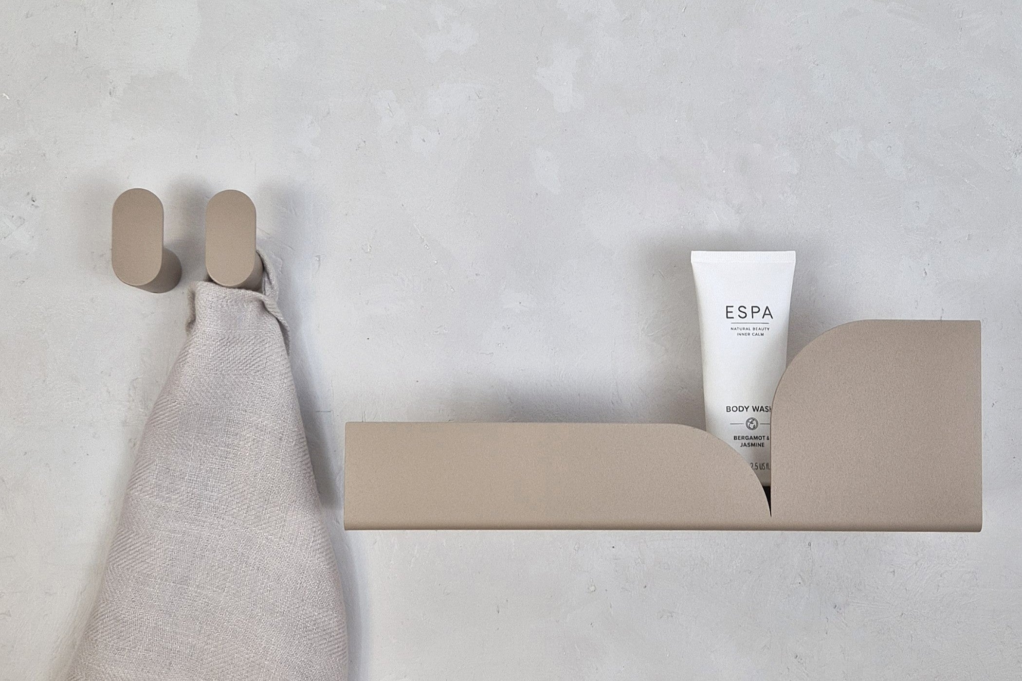 Warm minimalist bathroom with neutral decor featuring ESPA body wash and soft linen.