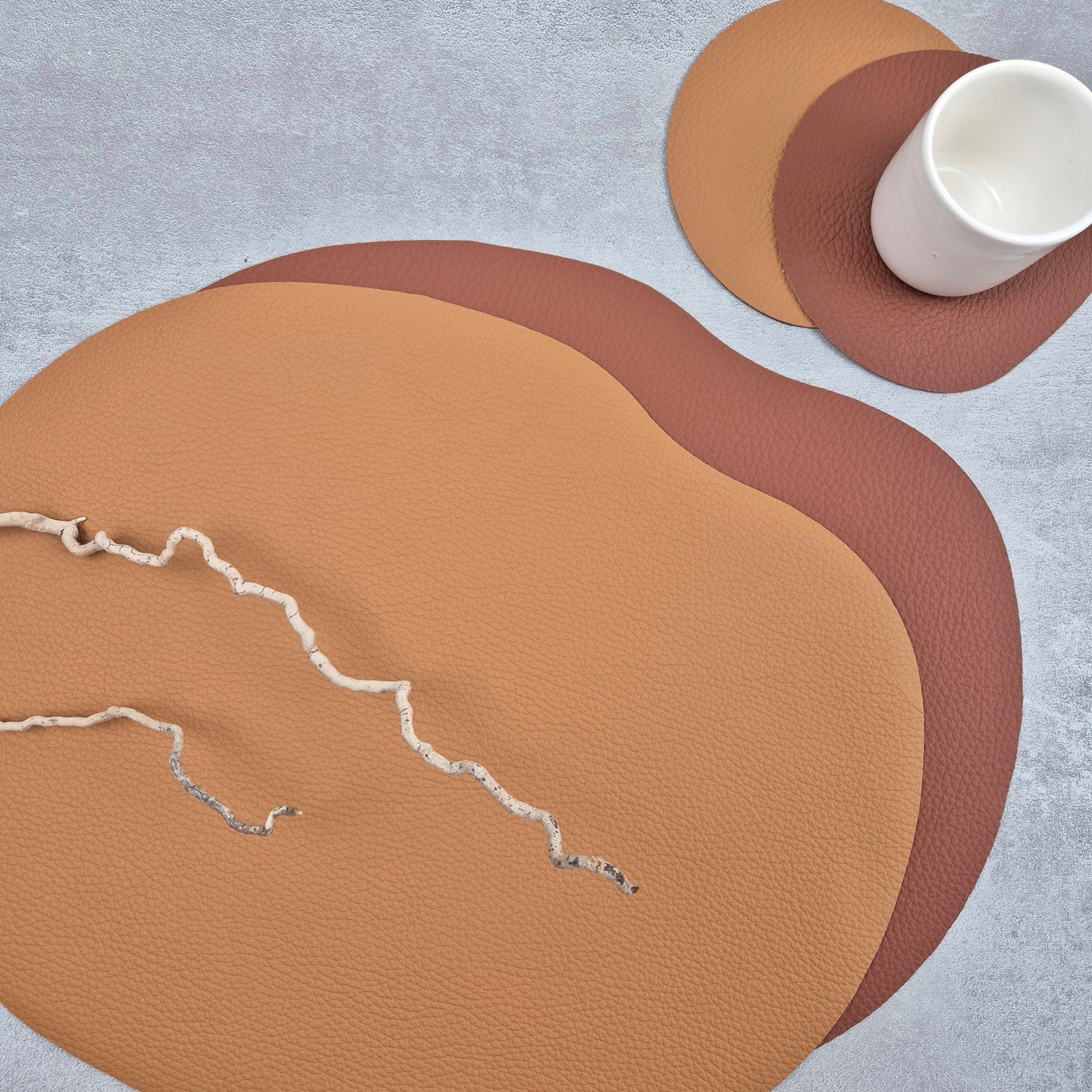 Stylish leather placemat and coaster set in warm tones with organic wavy shapes for an elegant dining experience.