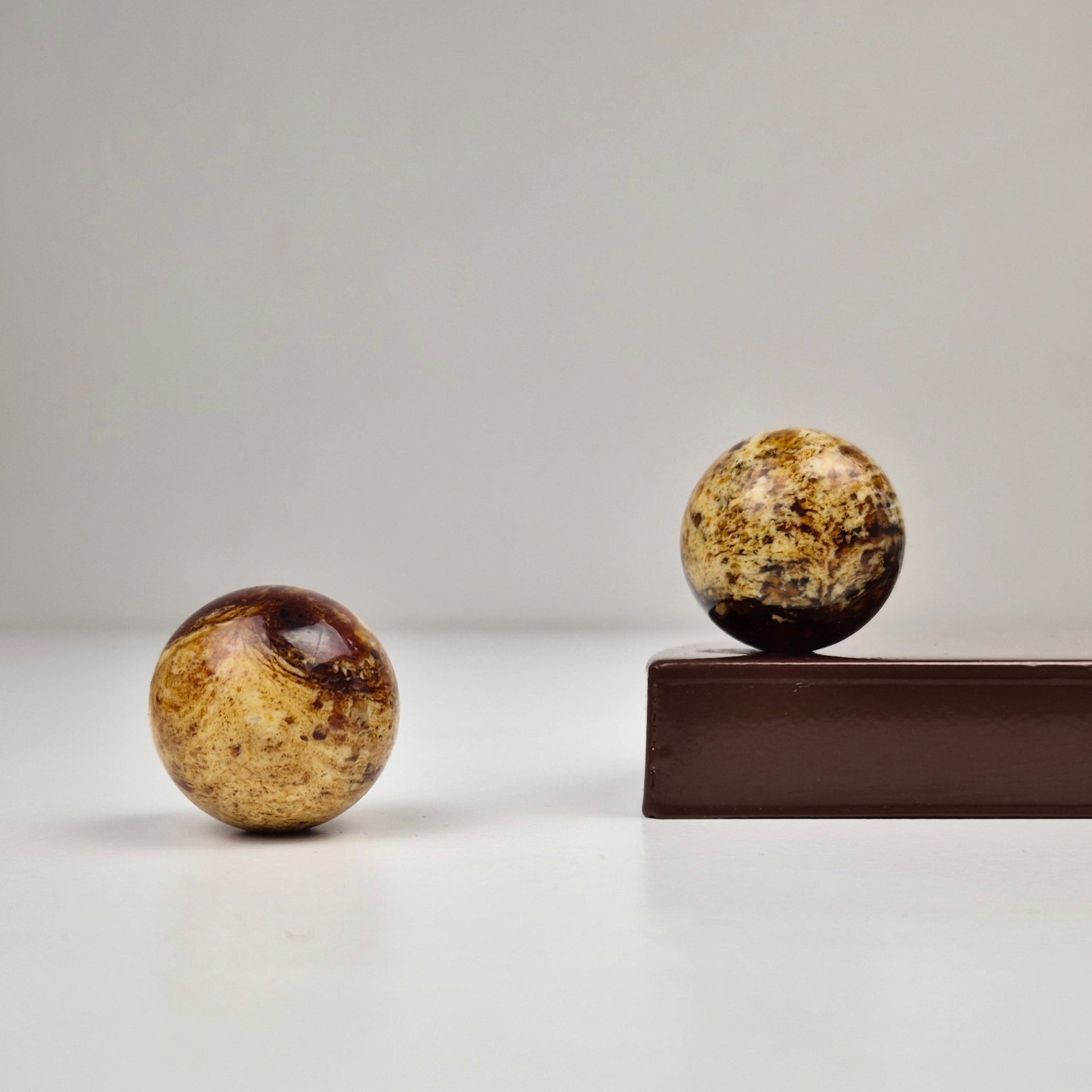 Round knob AMBER showcasing two round amber knobs on a dark surface, emphasizing their modern design and luxurious quality.