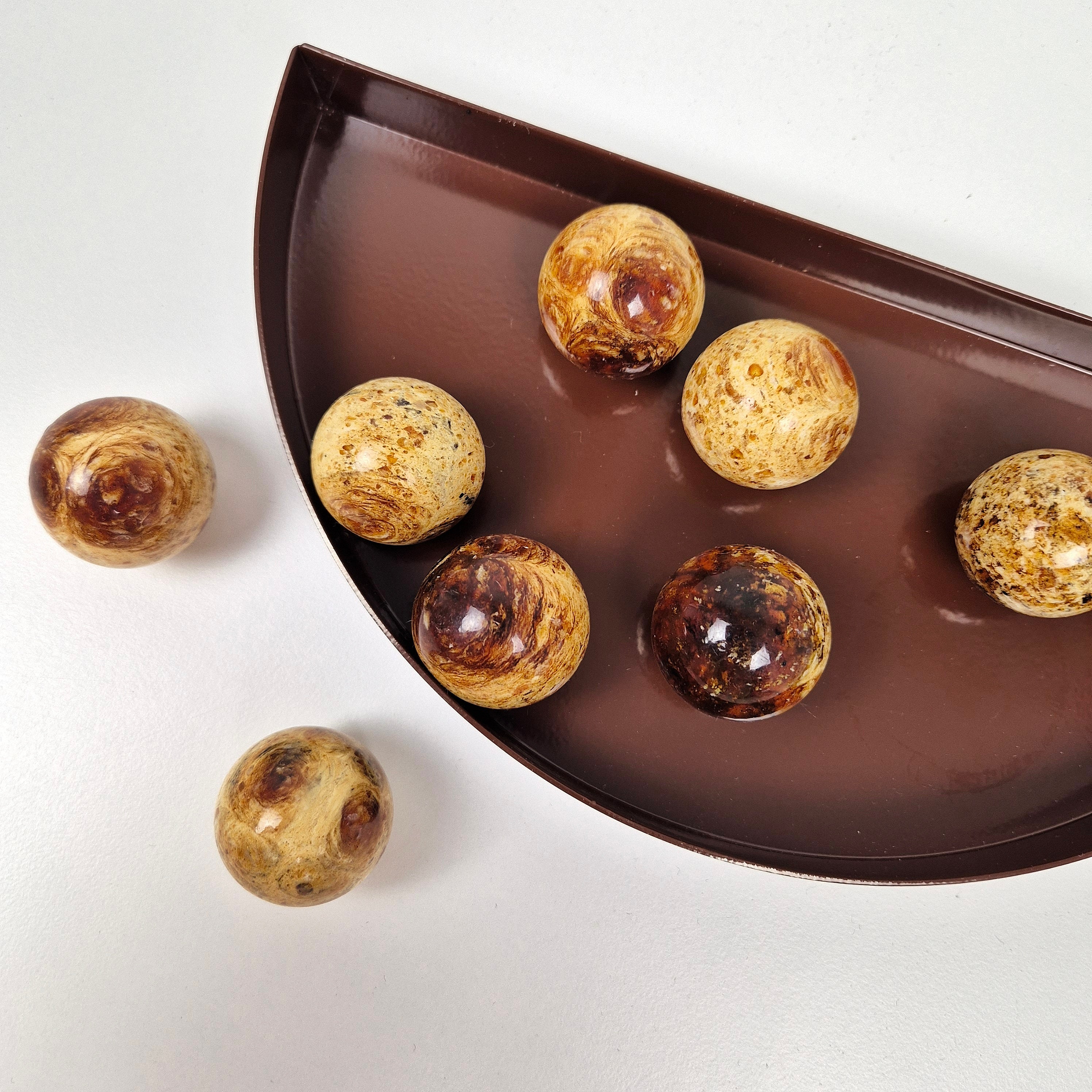 Round knob AMBER displayed on a brown dish, showcasing multiple amber knobs with unique patterns.