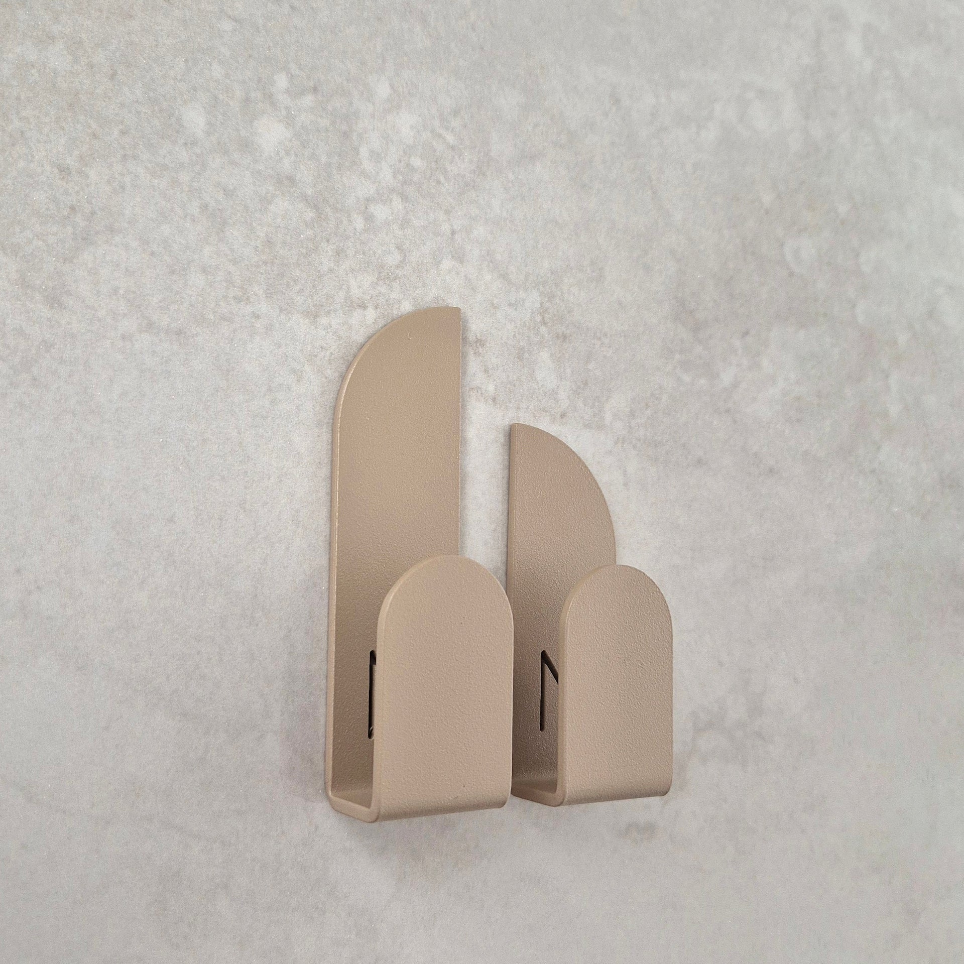 Adhesive wall hooks in a clean geometric design, ideal for organizing essentials in any room.