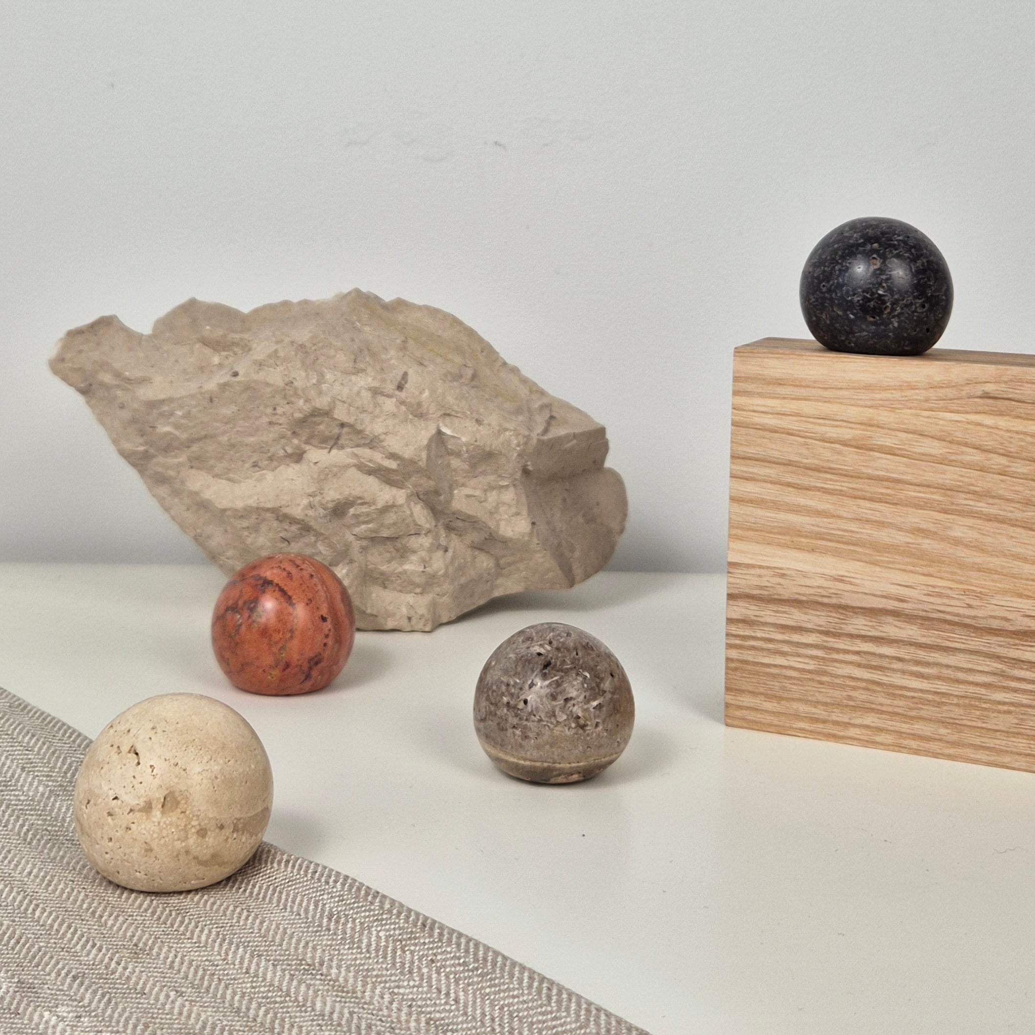 Natural stone decor pieces on a table featuring a stone cabinet knob and unique textures.