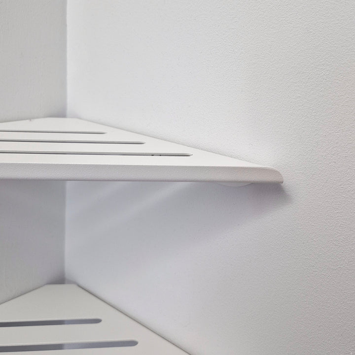 Close-up of a minimalist white shower corner shelf with clean lines and matte finish.