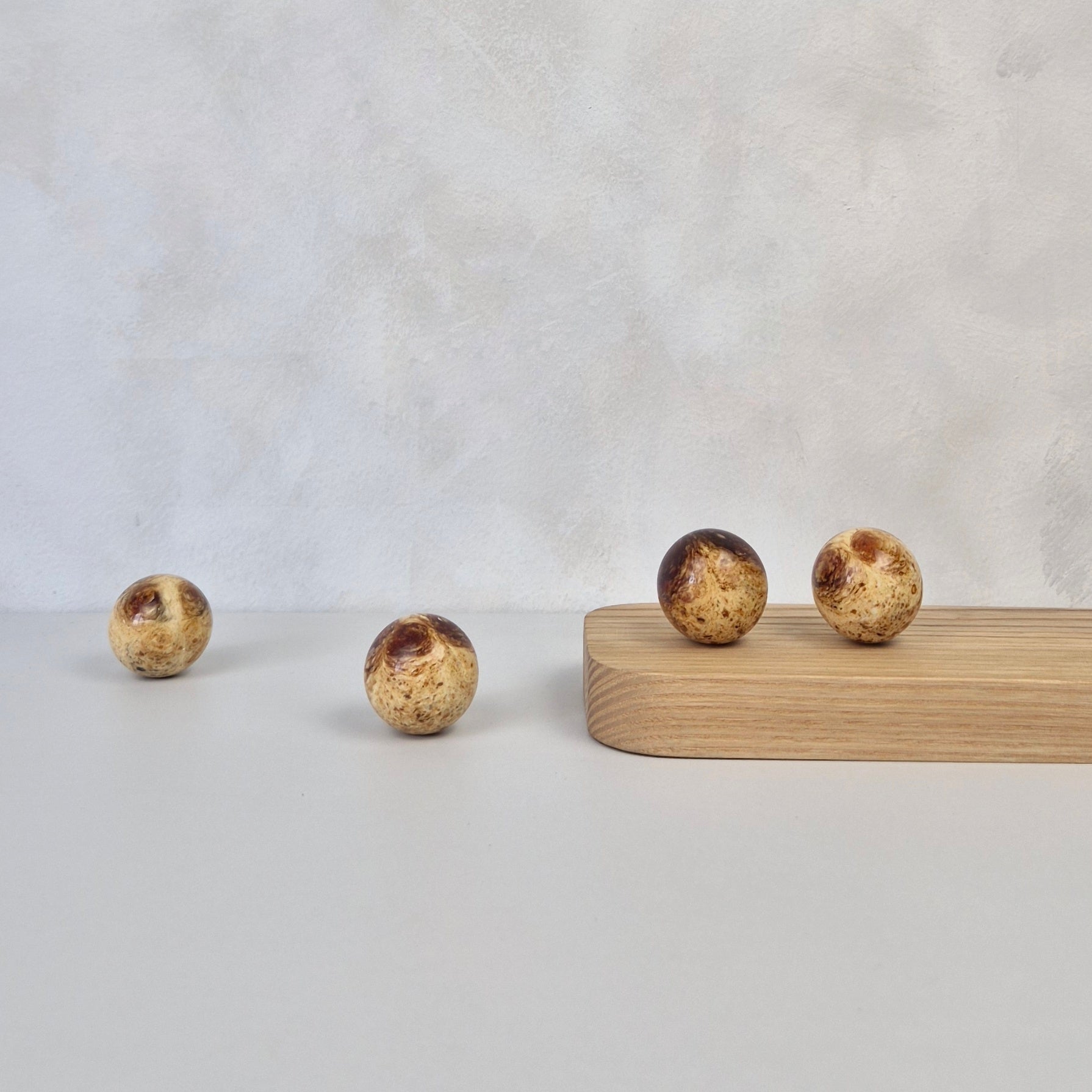 Round amber knob displayed on a wood surface, showcasing modern design and luxurious material.
