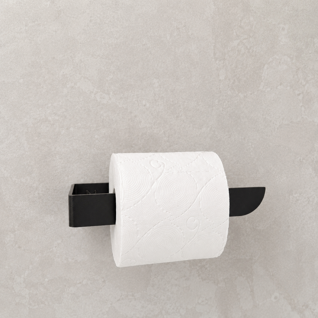 Black toilet paper holder mounted on a light gray wall, holding a roll of white paper towels.