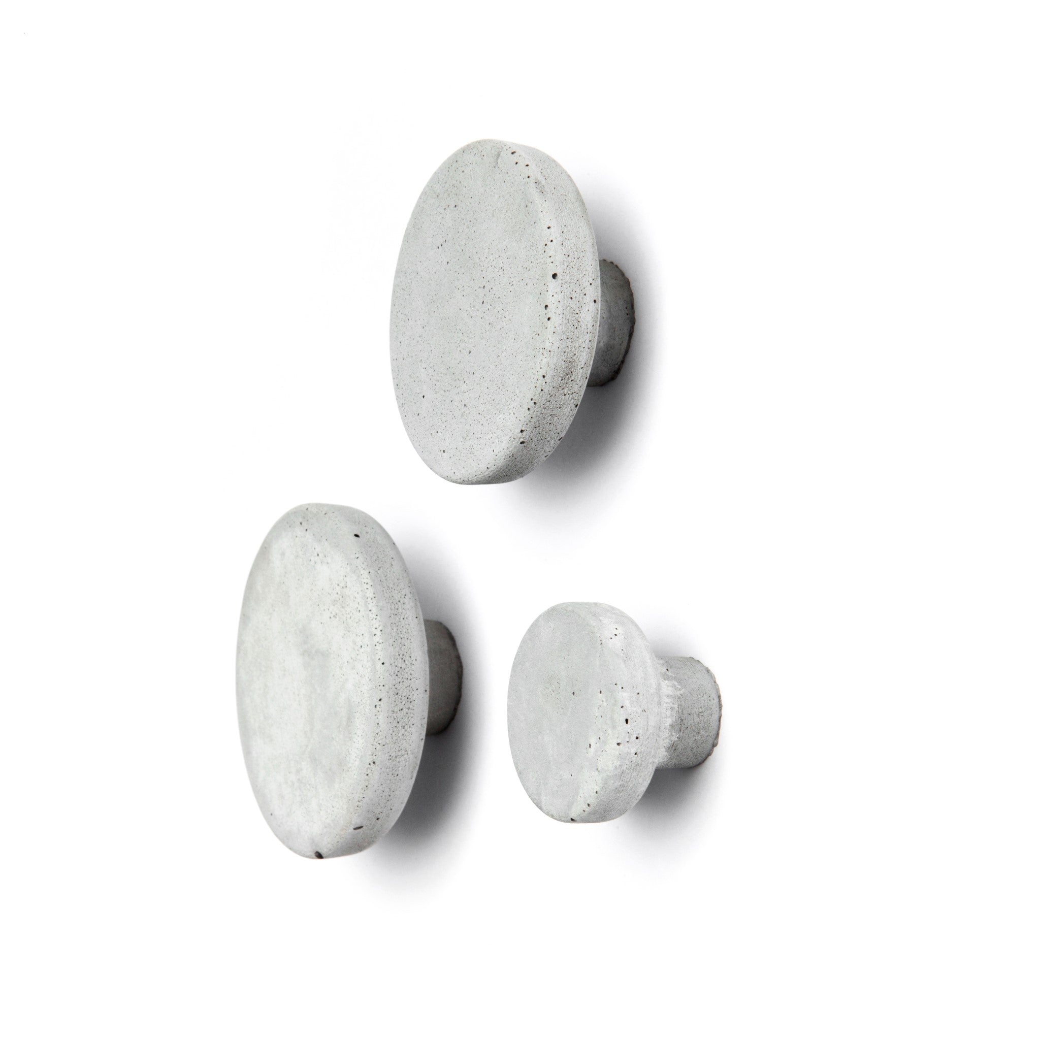 Set of three light grey concrete wall hooks, perfect for storage and decoration. Concrete wall hook for various uses.