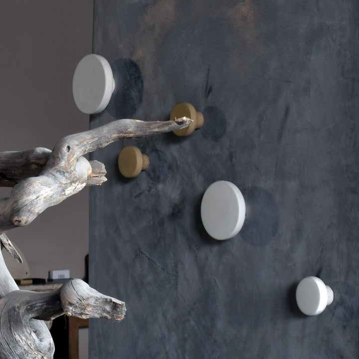 Concrete wall hook ivory POMOLO displayed on a textured wall with natural wood accents.